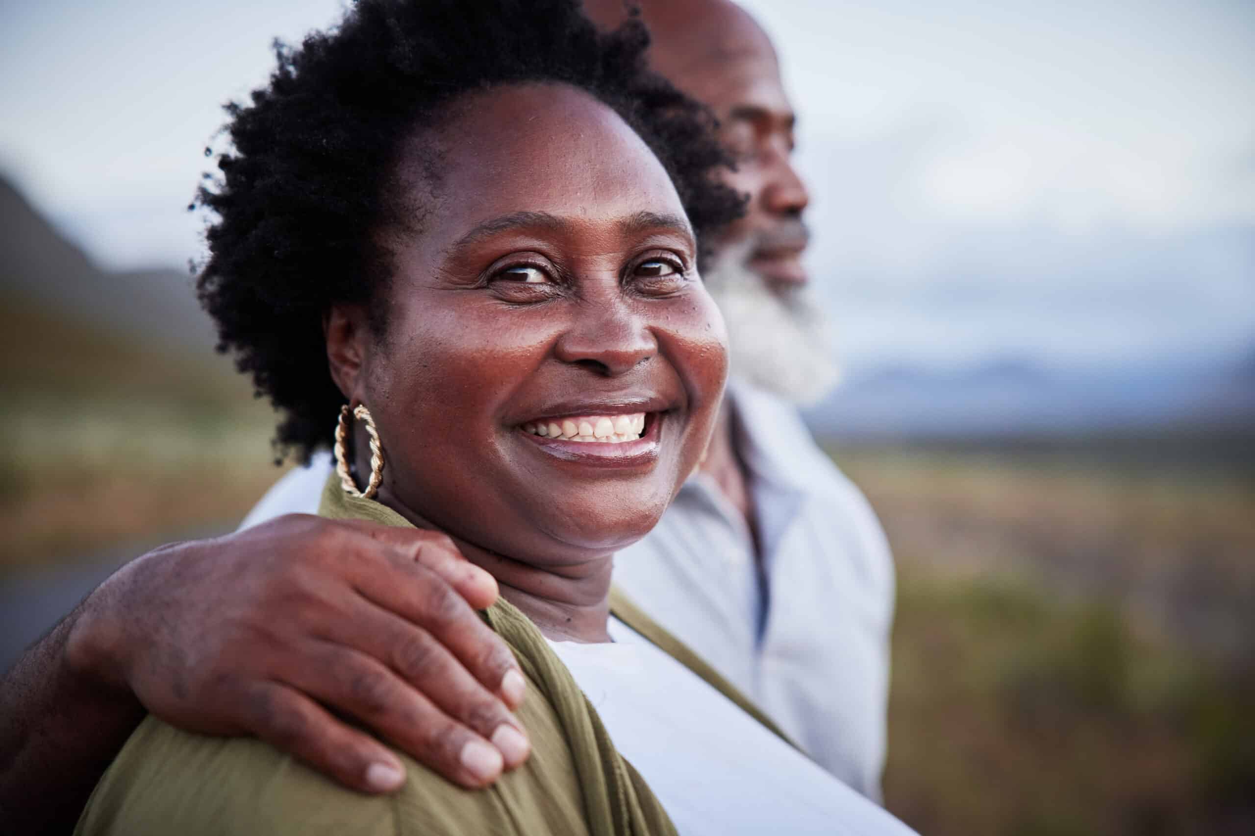 Smiling mature woman standing in the countryside with her husband