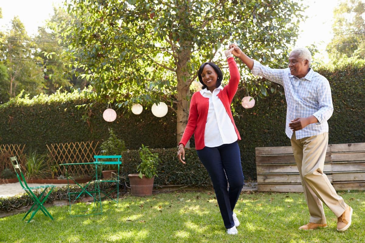 Old couple dancing n the backyard, having fun